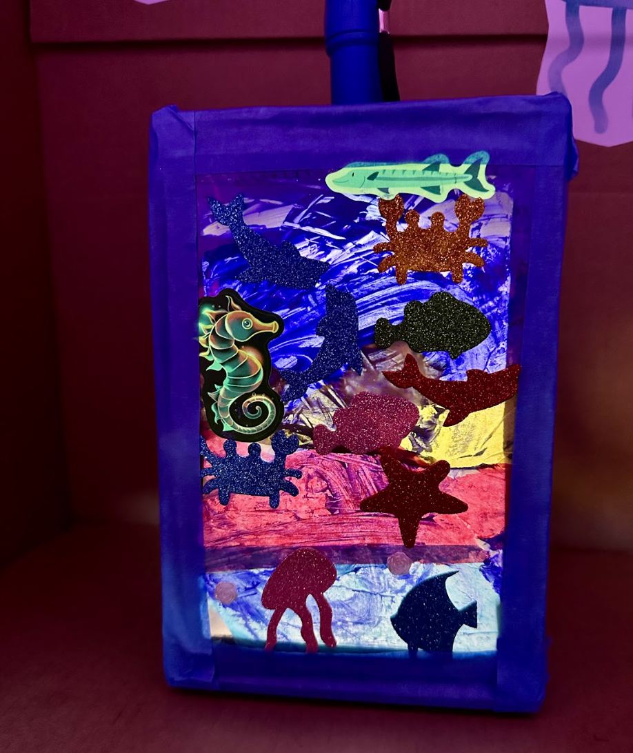 A completed ocean scene lantern, illuminated from within.