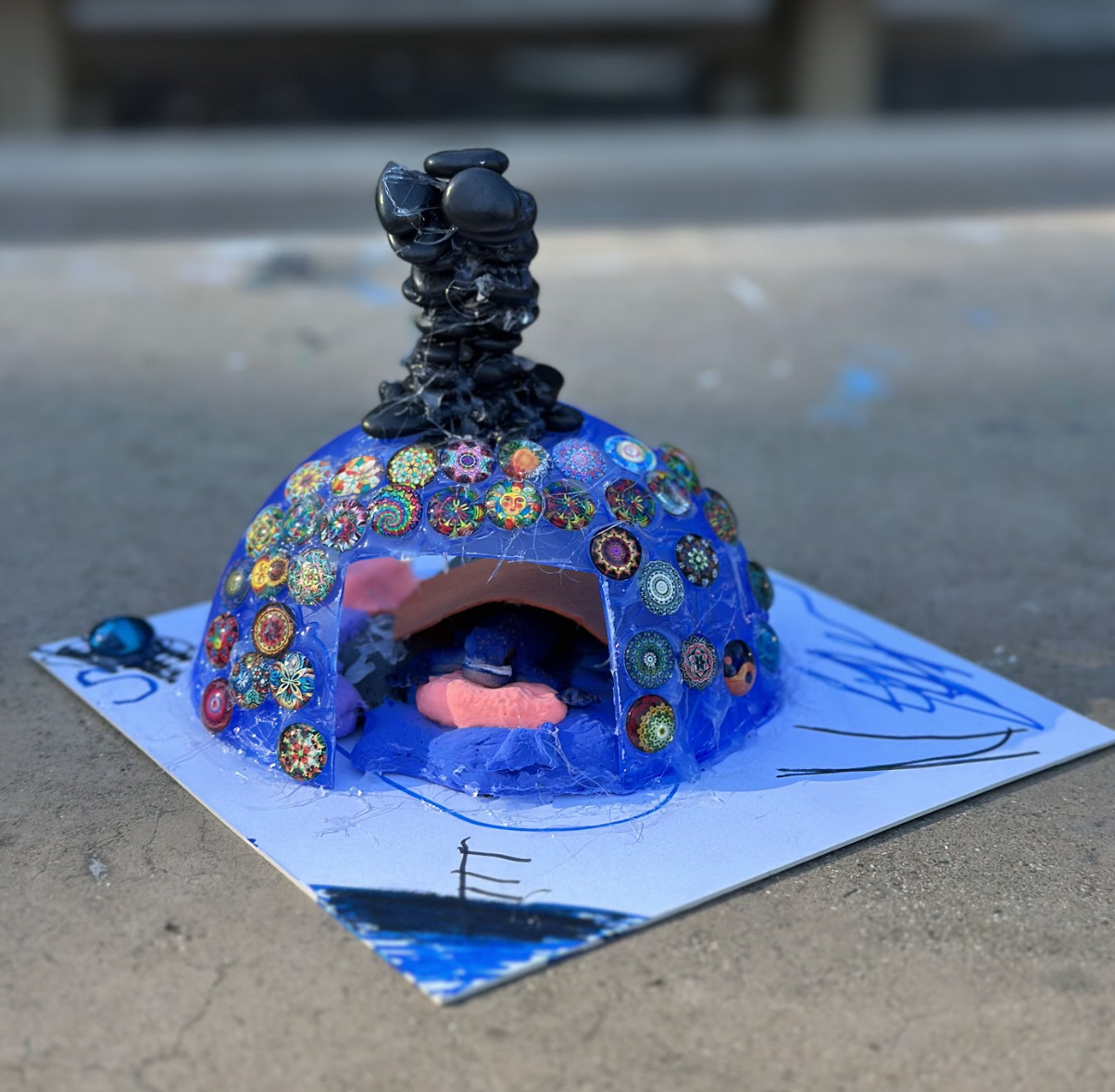 A decorated shelter designed to absorb warmth for a lizard.